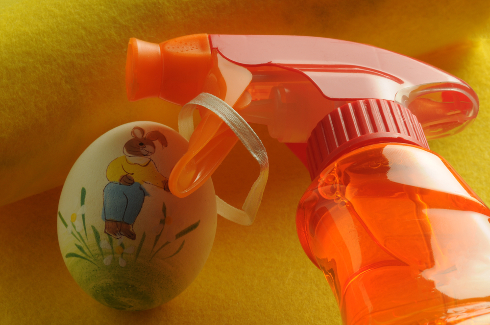 Spray bottle nozzle next to an Easter egg